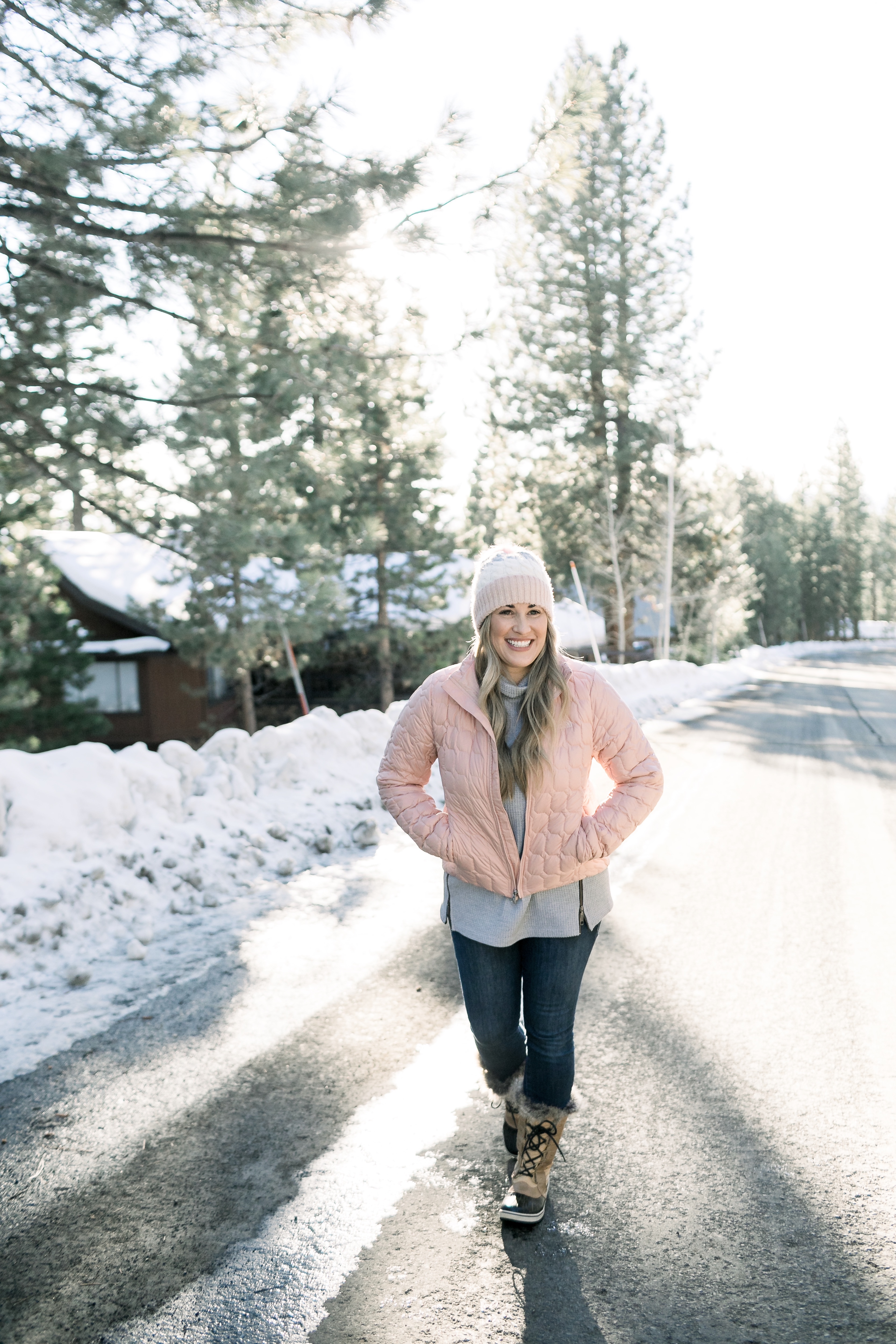 How to Wear Pastels in the Winter, fashion tips featured by top Memphis blog, Walking in Memphis in High Heels: image of a woman wearing a light pink The North Face crop jacket, ASOS blush pom beanie, Sorel blush snow boots.