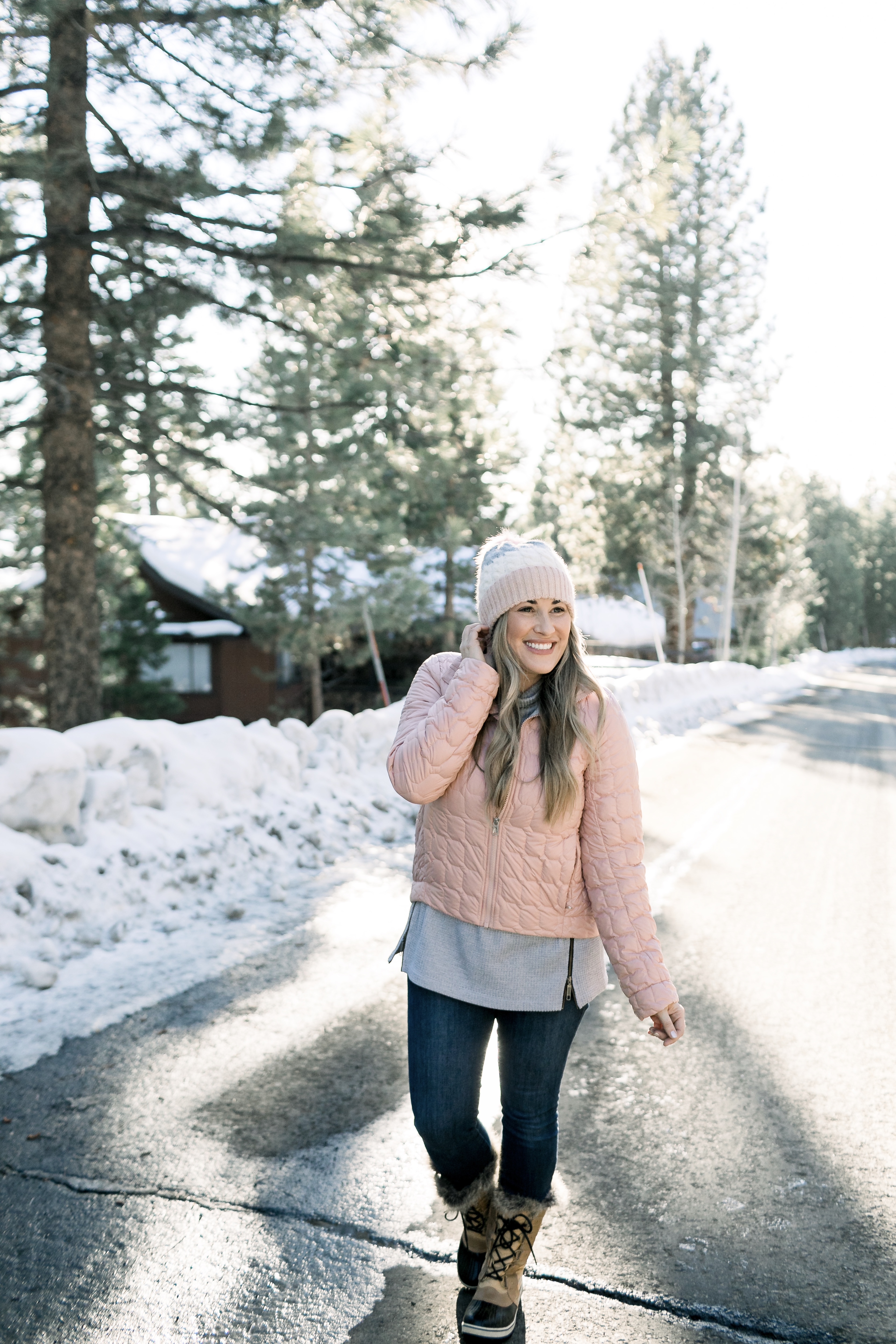 How to Wear Pastels in the Winter, fashion tips featured by top Memphis blog, Walking in Memphis in High Heels: image of a woman wearing a light pink The North Face crop jacket, ASOS blush pom beanie, Sorel blush snow boots.