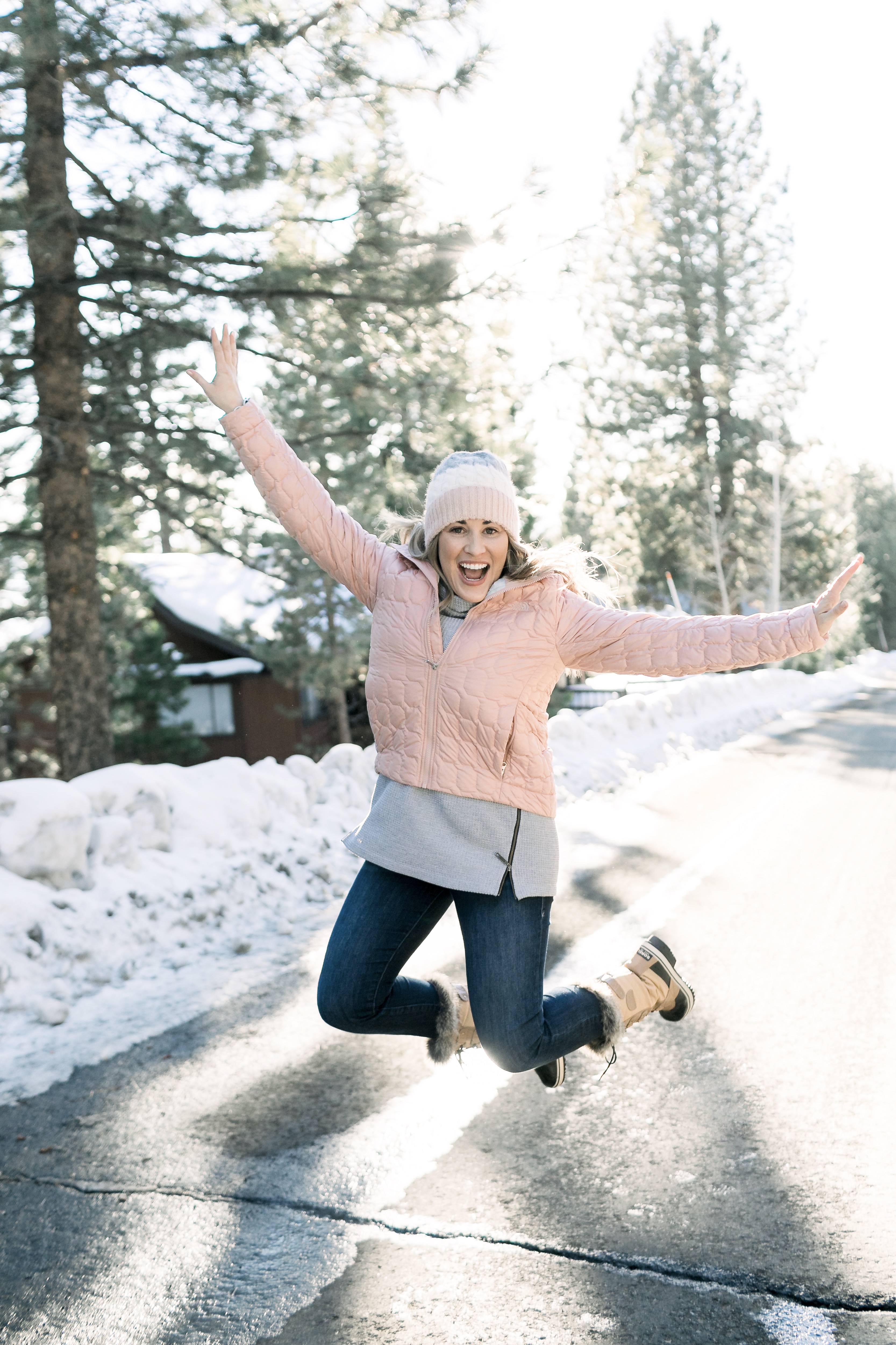 How to Wear Pastels in the Winter, fashion tips featured by top Memphis blog, Walking in Memphis in High Heels: image of a woman wearing a light pink The North Face crop jacket, ASOS blush pom beanie, Sorel blush snow boots.