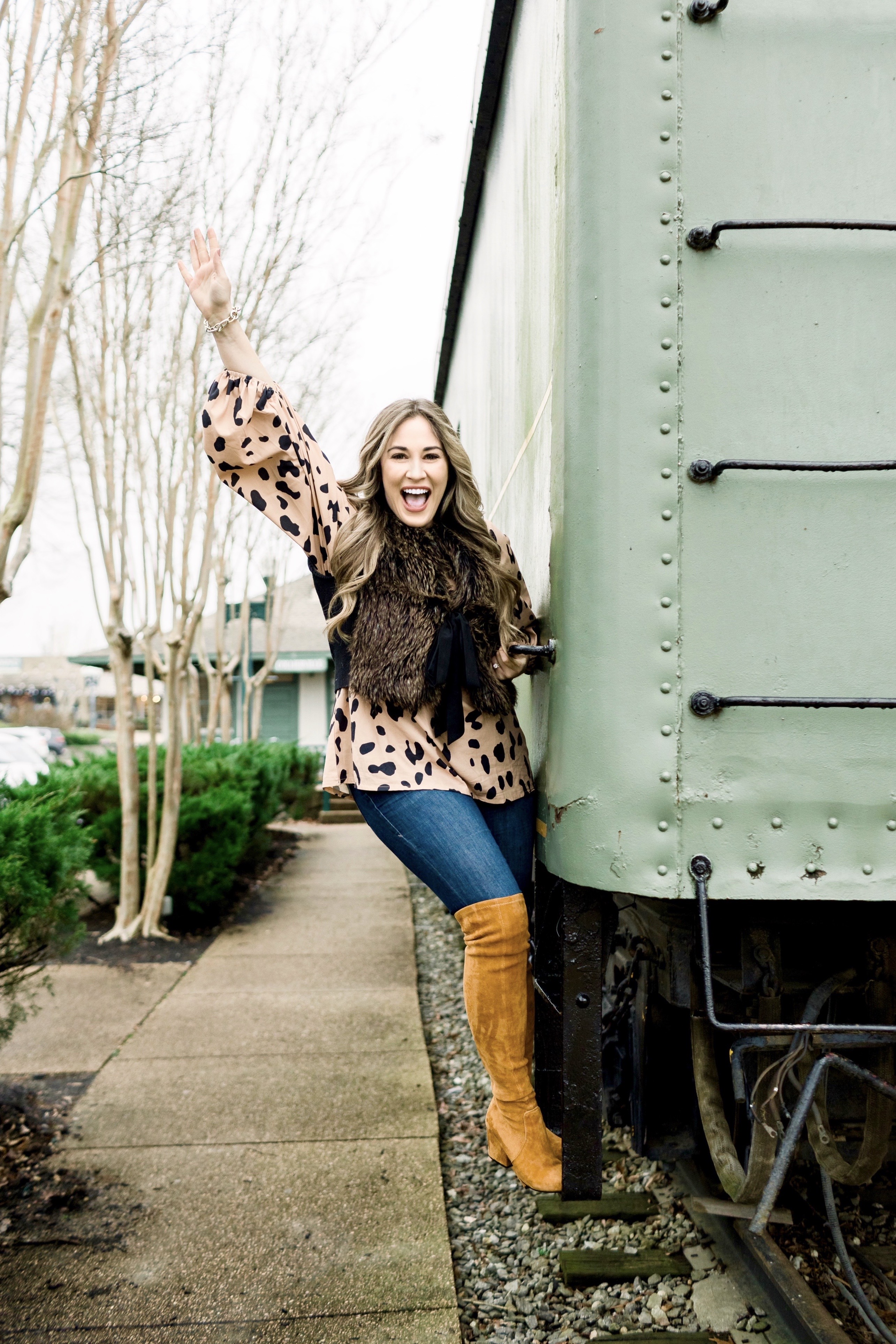 Animal print top styled by top Memphis fashion blog, Walking in Memphis in High Heels: image of a woman wearing an Amazon Chiffon animal print top, LOFT faux fur vest, Good American jeans and Goodnight Macaroon over the knees suede boots.