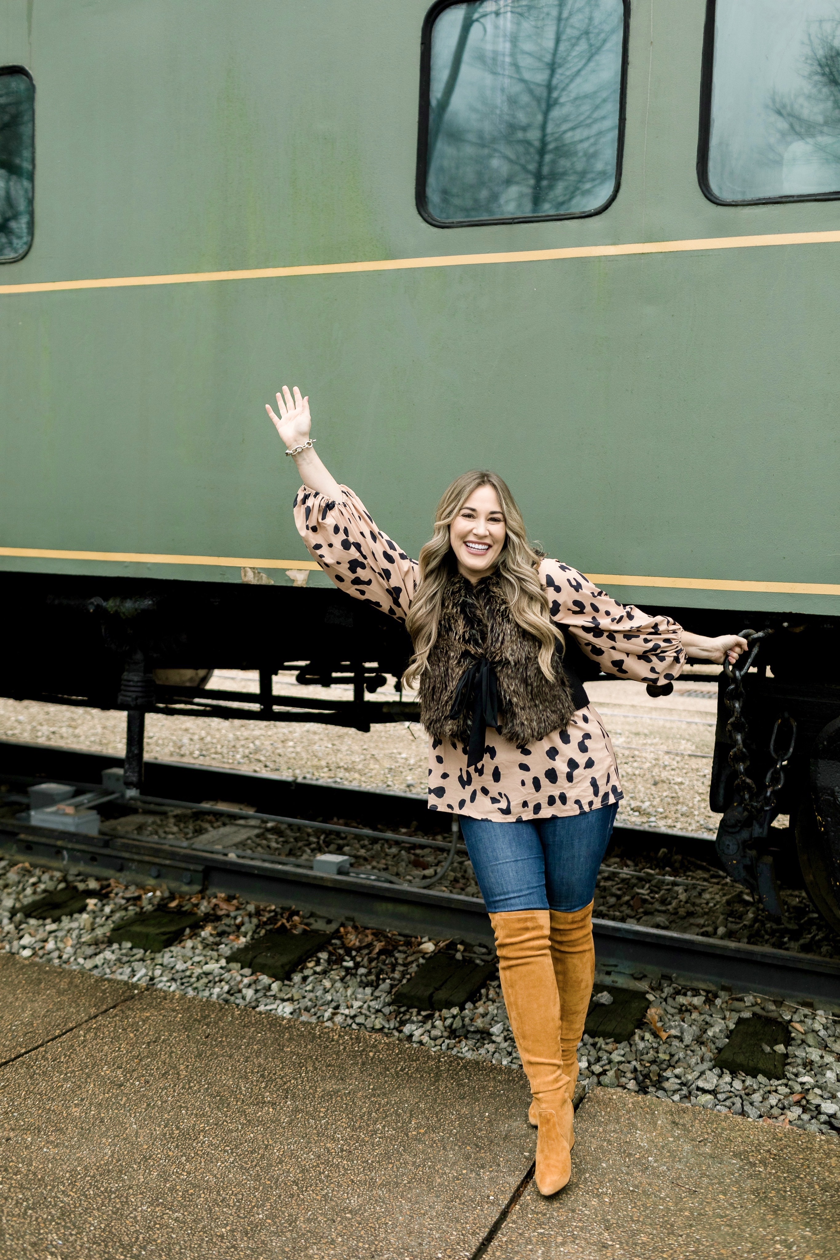 Animal print top styled by top Memphis fashion blog, Walking in Memphis in High Heels: image of a woman wearing an Amazon Chiffon animal print top, LOFT faux fur vest, Good American jeans and Goodnight Macaroon over the knees suede boots.
