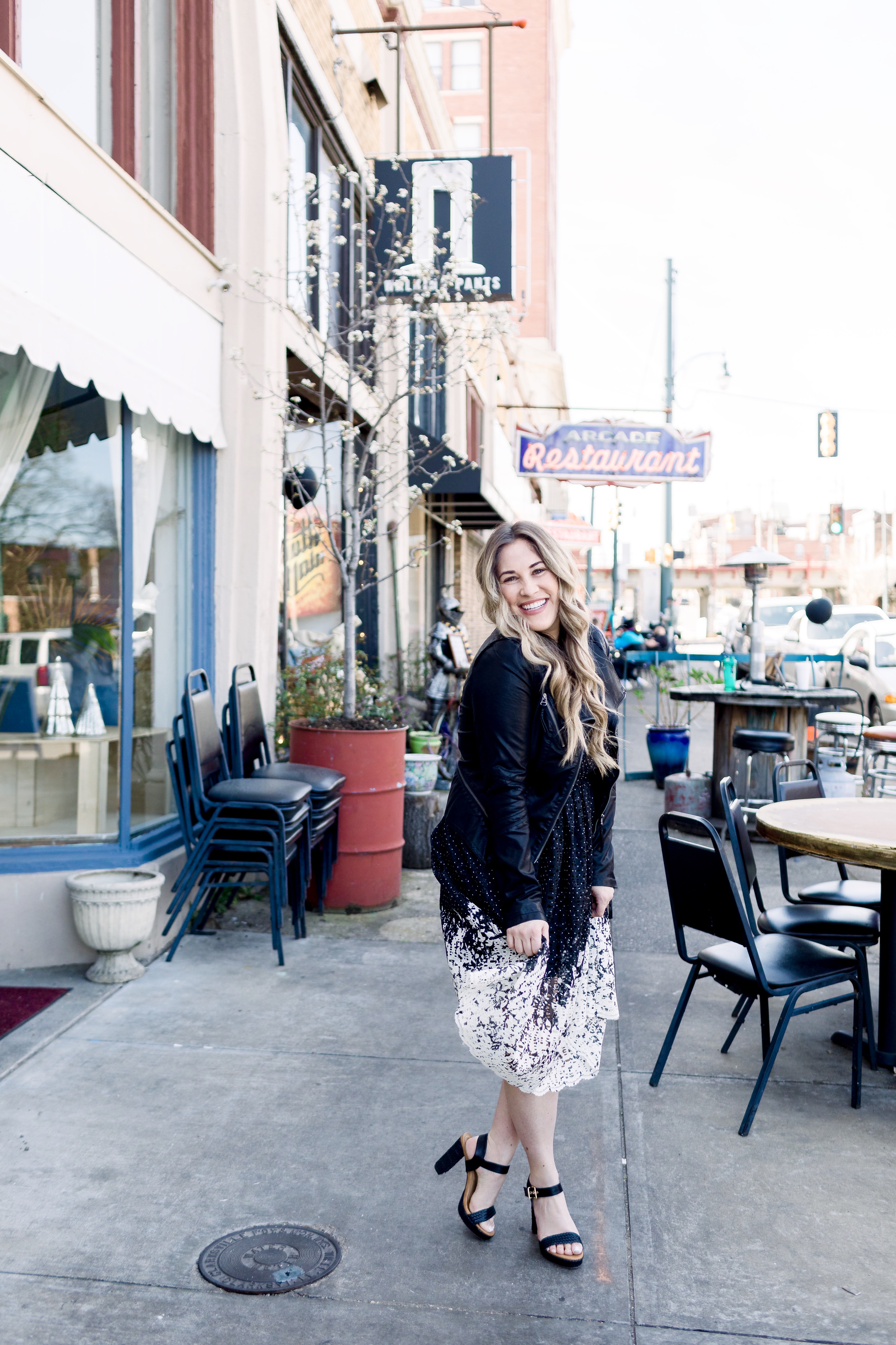 How to wear black in the spring, styling tips featured by top Memphis fashion blog, Walking in Memphis in High Heels: image of a woman wearing a black and white Eliza J lace dress, Levi’s faux leather Moto jacket, RAID platform sandals.