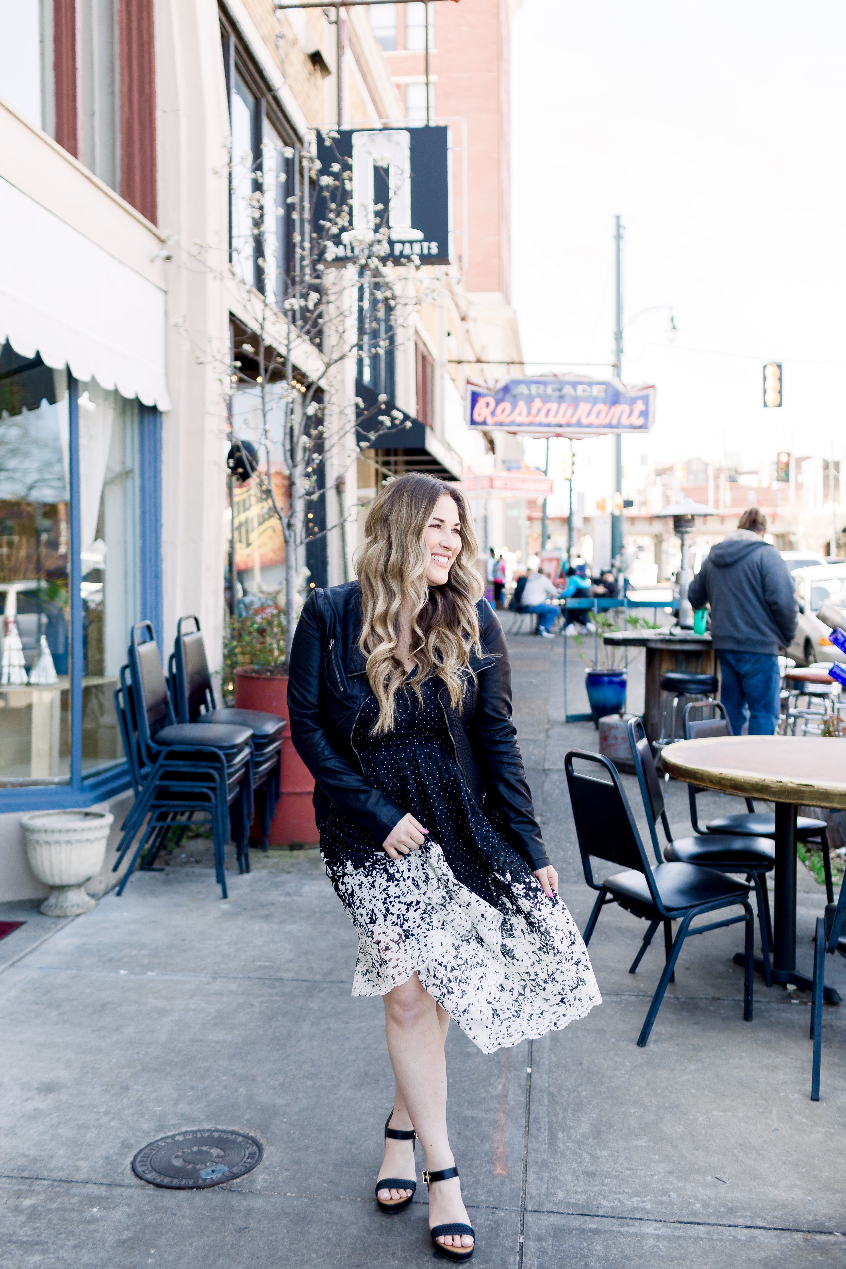 How to wear black in the spring, styling tips featured by top Memphis fashion blog, Walking in Memphis in High Heels: image of a woman wearing a black and white Eliza J lace dress, Levi’s faux leather Moto jacket, RAID platform sandals.