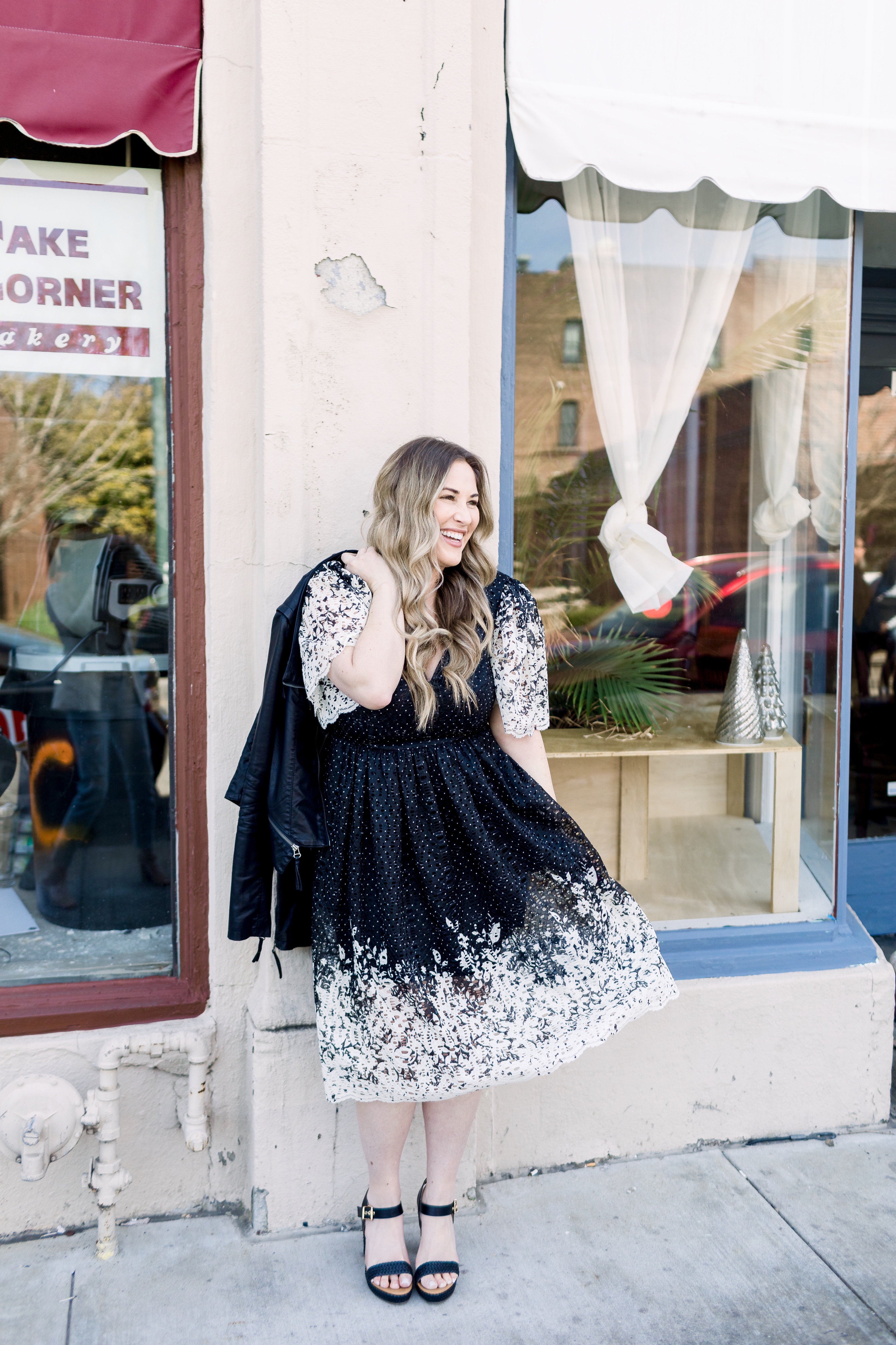 How to wear black in the spring, styling tips featured by top Memphis fashion blog, Walking in Memphis in High Heels: image of a woman wearing a black and white Eliza J lace dress, Levi’s faux leather Moto jacket, RAID platform sandals.