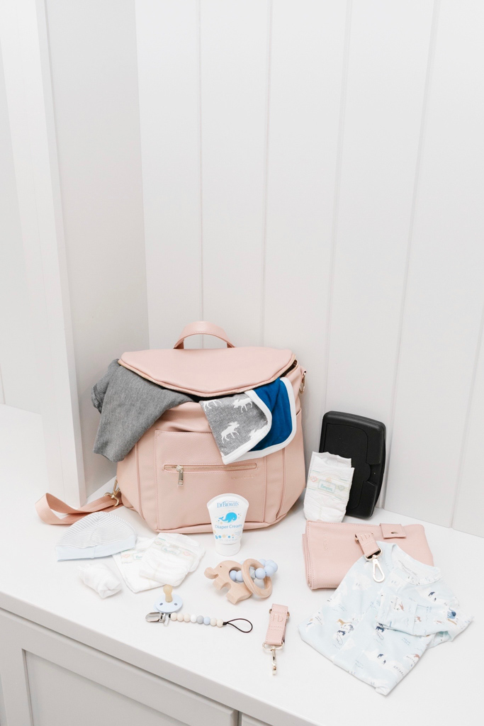 Diaper Bag Essentials featured by top Memphis mommy blogger, Walking in Memphis in High Heels: image of a woman wearing a Fawn Design blush diaper bag.