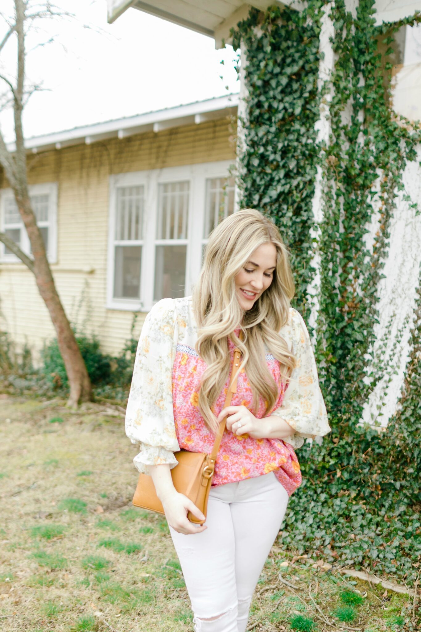 Cute Spring Outfit styled by top Memphis fashion blogger, Walking in Memphis in High Heels: image of a woman wearing a Red Dress Boutique floral top, Express high waisted skinny white jeans, and Gigi New York crossbody bag.