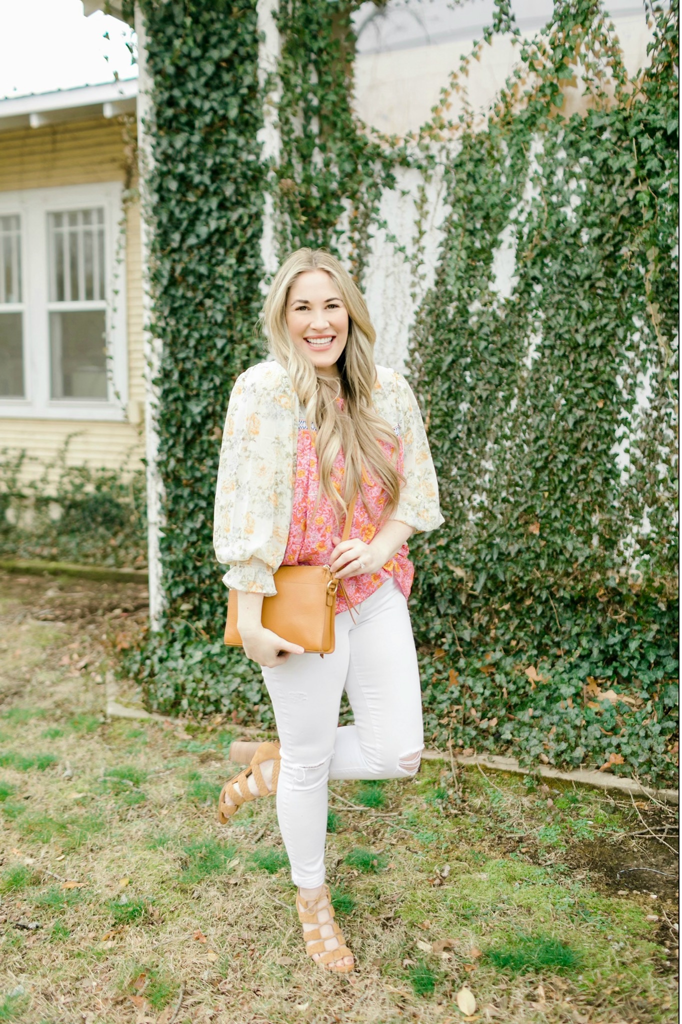 Cute Spring Outfit styled by top Memphis fashion blogger, Walking in Memphis in High Heels: image of a woman wearing a Red Dress Boutique floral top, Express high waisted skinny white jeans, and Gigi New York crossbody bag.