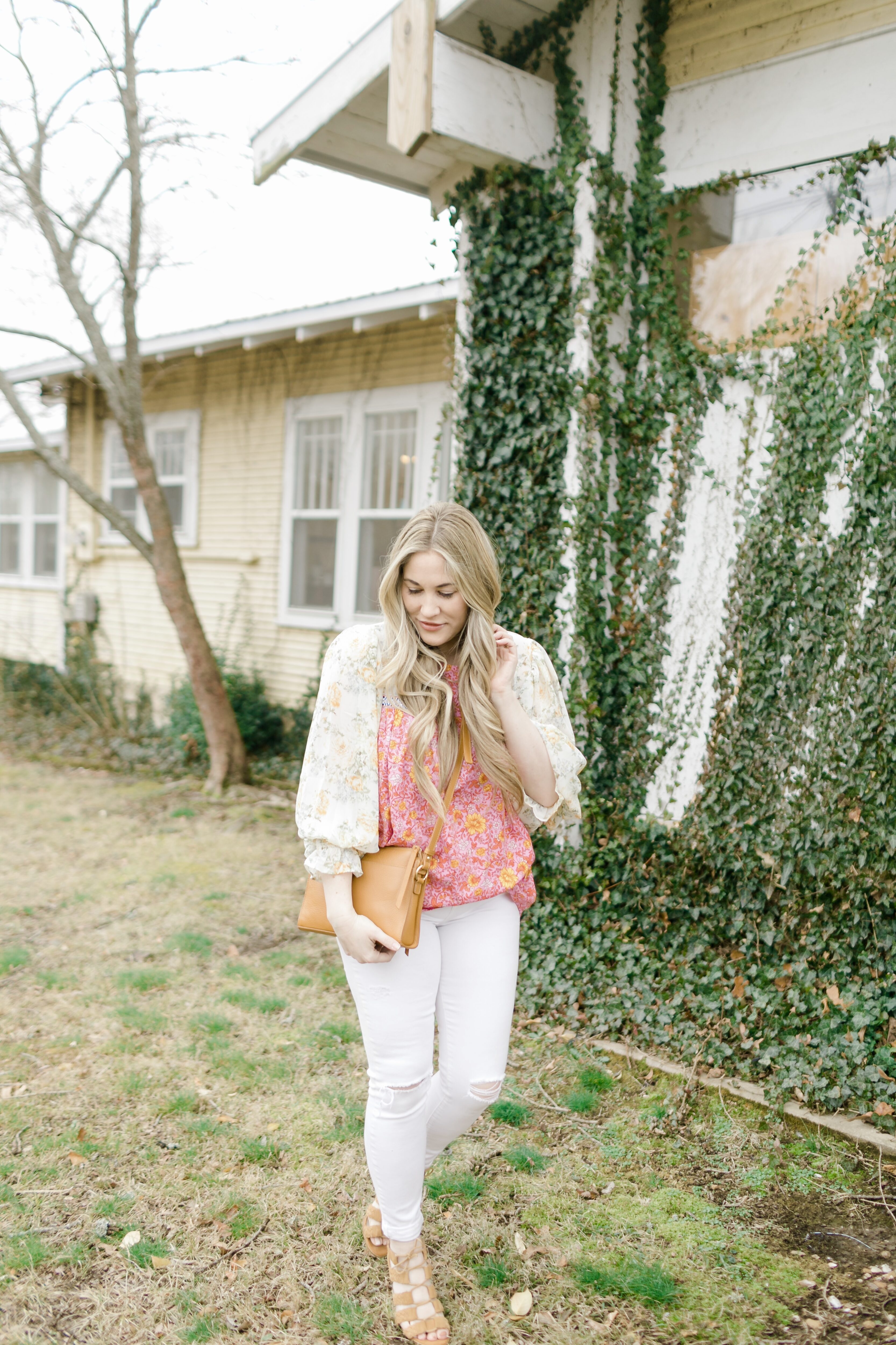 Cute Spring Outfit styled by top Memphis fashion blogger, Walking in Memphis in High Heels: image of a woman wearing a Red Dress Boutique floral top, Express high waisted skinny white jeans, and Gigi New York crossbody bag.