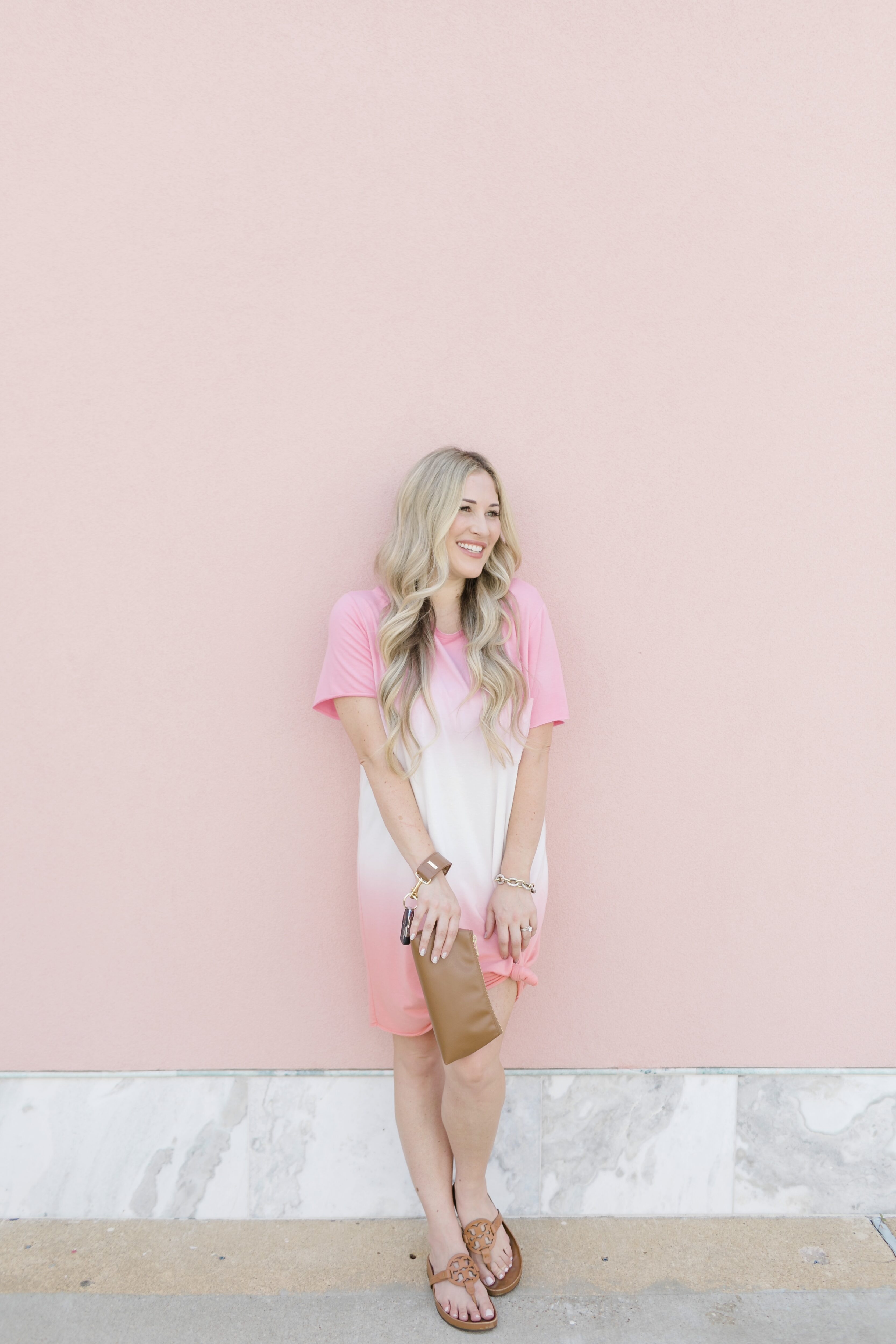 Late summer casual outfit featured by top US mommy fashion blogger, Walking in Memphis in High Heels: image of a woman wearing a Mud Pie pink tie dye dress, Tory Burch sandals and a Keyper wristlet.